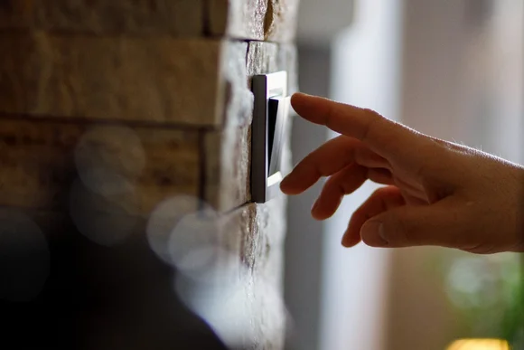 Hand betätigt einen Lichtschalter.